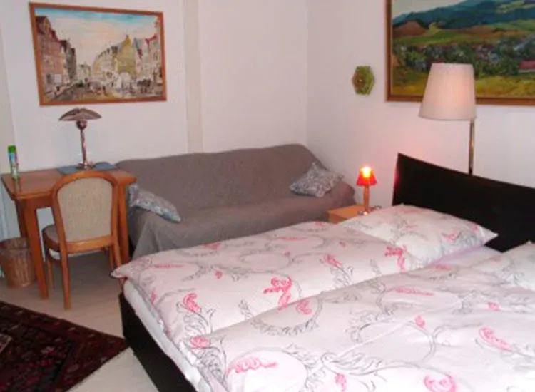 Schlafzimmer mit Doppelbett und Beistellcouch, Ferienhaus Barbara in Celle